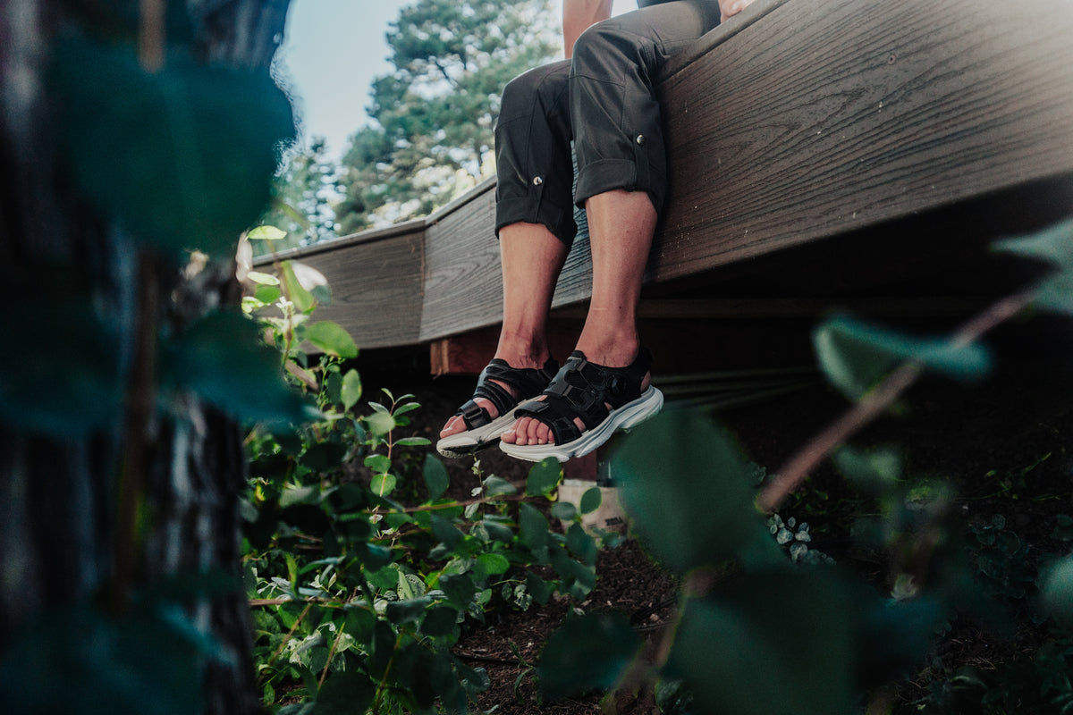 woman dangling legs off ledge wearing amento women's martlett in black